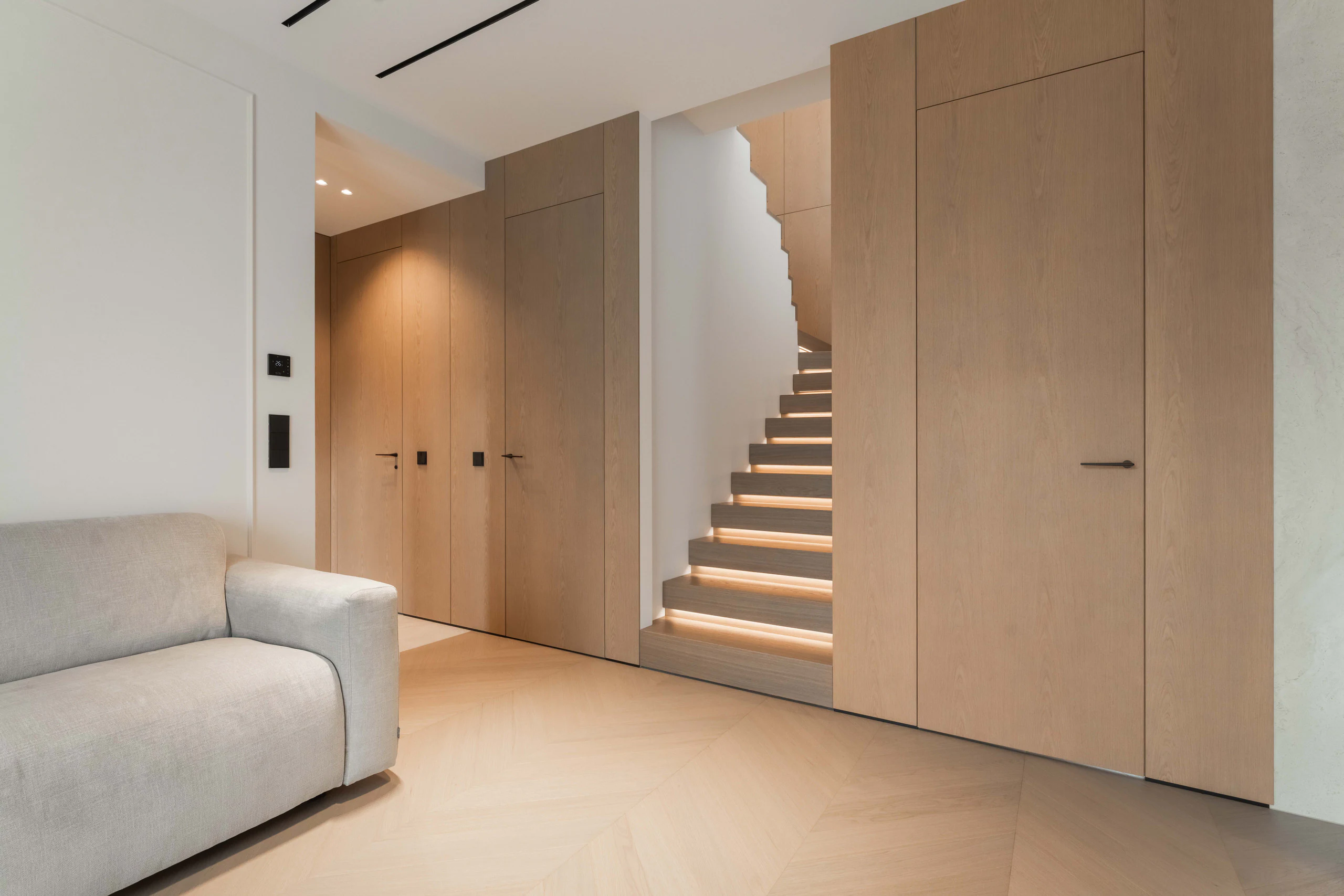 Oak panelling, integrated doors and illuminated staircase in an Estonian private residence
