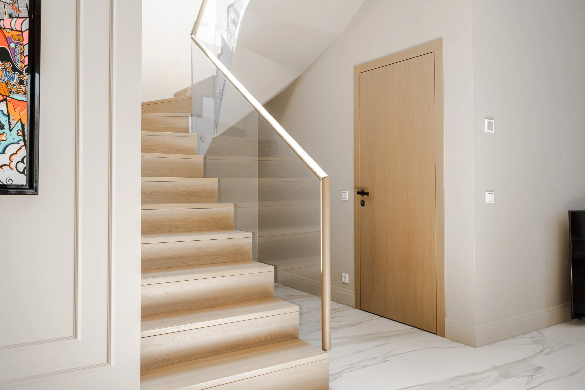 Light oak staircase with glass balustrade and flush interior door